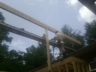 Carpenter setting a ridge beam over a new addition frame — Ice Dam Removal by Roofing Brothers in Moxee