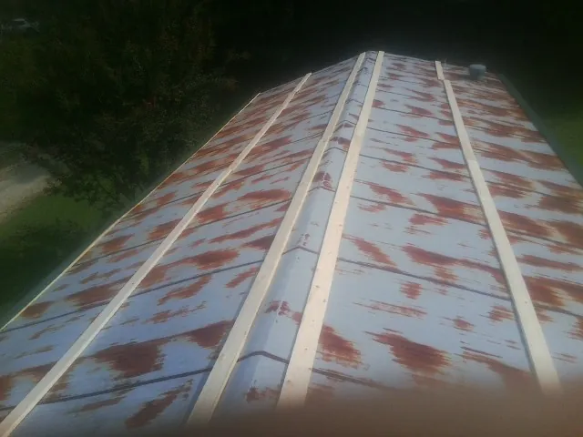 Rusted metal roof panels with new wood purlins before replacement — Storm Damage Roof Repair in Moxee by Roofing Brothers