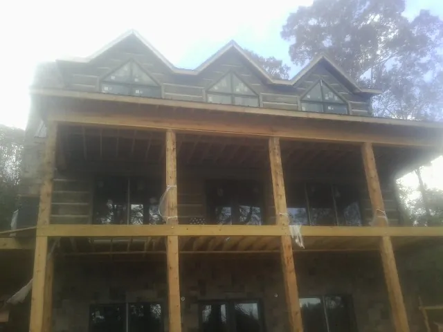 Dormers and porch framing on a large log home under construction — Roof Coating work by our crew in Moxee