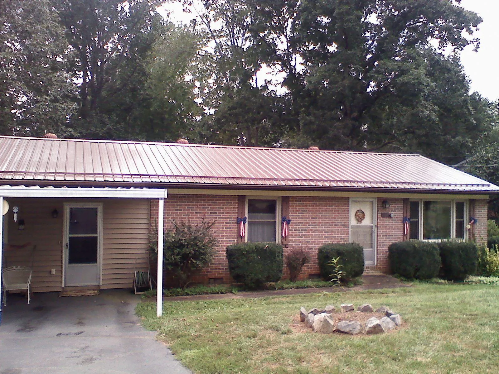 Bronze metal roof and carport on a brick ranch home — Roof Repair work by our crew in Moxee